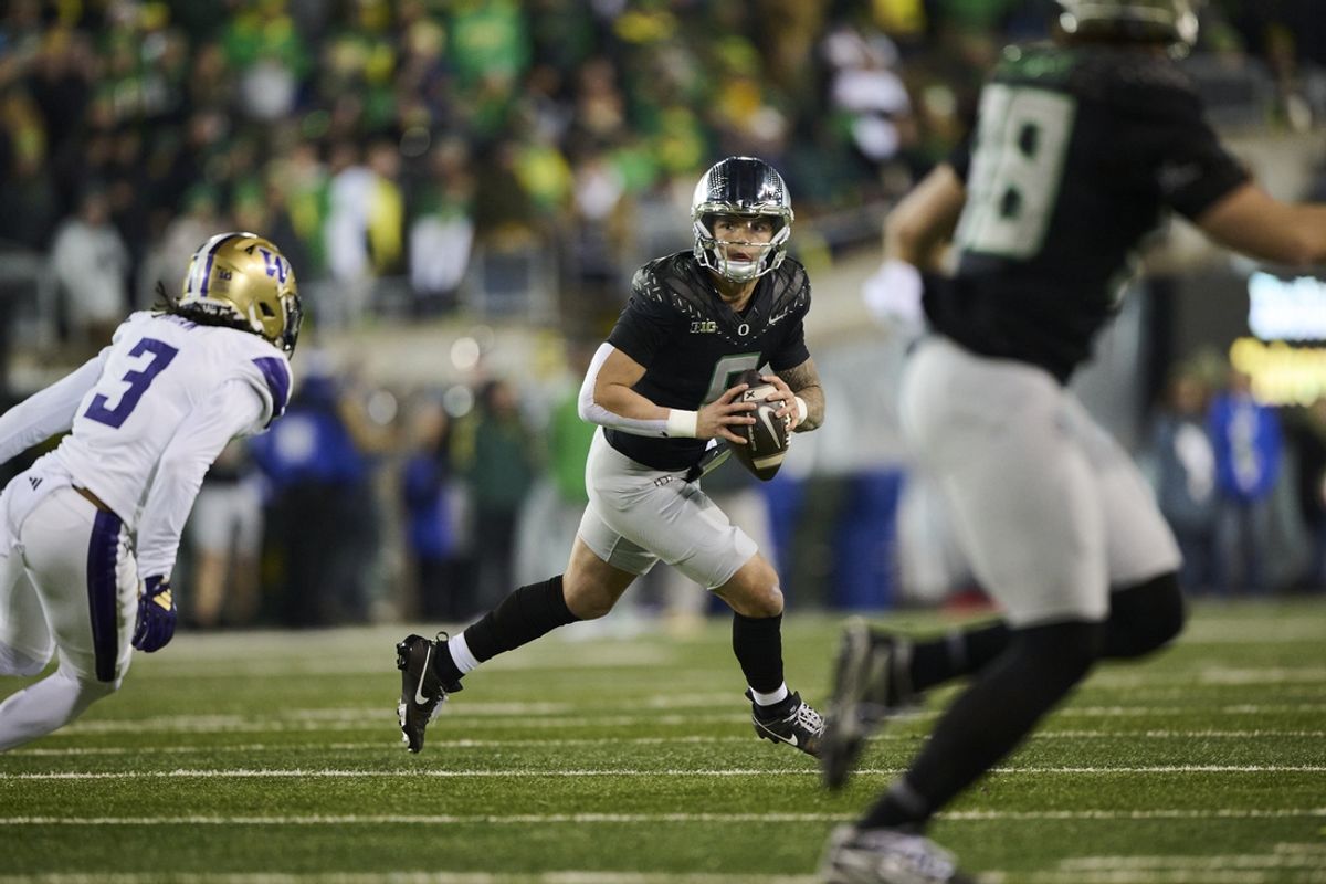 Nov 30, 2024; Eugene, Oregon, USA; Oregon Ducks quarterback Dillon Gabriel (8) looks for a receiver during the second half against Washington Huskies cornerback Jordan Shaw (3) at Autzen Stadium. Mandatory Credit: Troy Wayrynen-Imagn Images