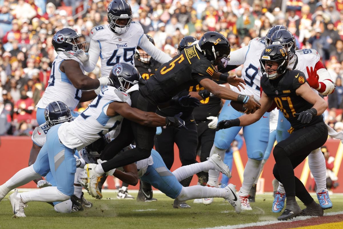 Dec 1, 2024; Landover, Maryland, USA; Washington Commanders quarterback Jayden Daniels (5) scores a touchdown against the Tennessee Titans during the first half at Northwest Stadium. Mandatory Credit: Amber Searls-Imagn Images