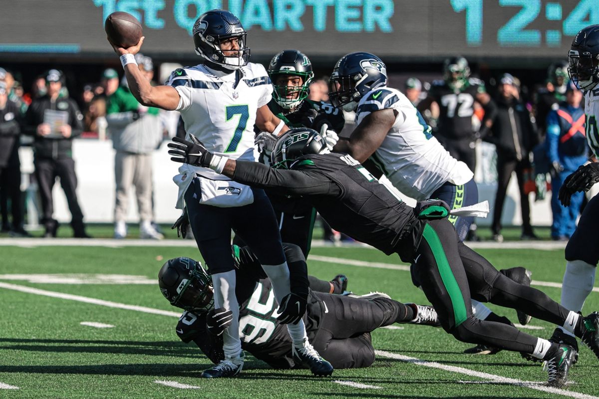 Dec 1, 2024; East Rutherford, New Jersey, USA; Seattle Seahawks quarterback Geno Smith (7) throws the ball as New York Jets defensive tackle Quinnen Williams (95)  and defensive end Haason Reddick (7) tackle during the first quarter at MetLife Stadium. Mandatory Credit: Vincent Carchietta-Imagn Images