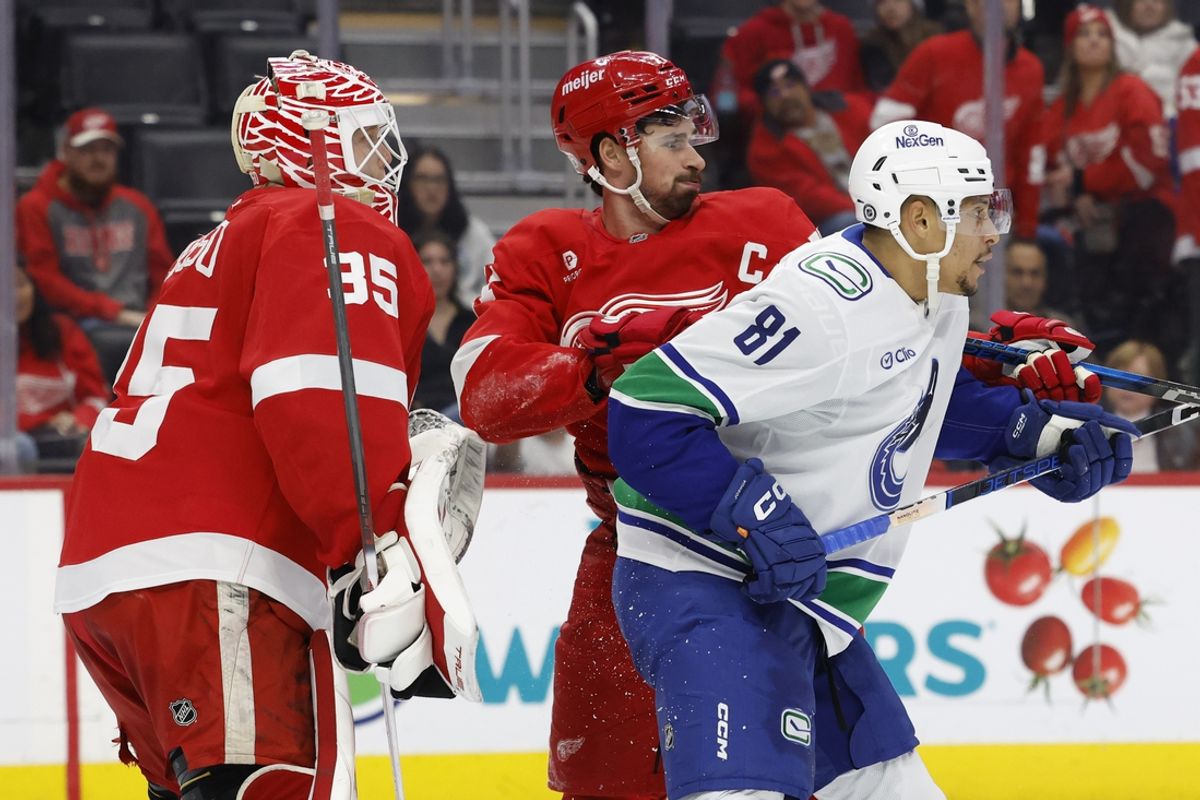 Dec 1, 2024; Detroit, Michigan, USA;  Detroit Red Wings center Dylan Larkin (71) and Vancouver Canucks center Dakota Joshua (81) fight for position in front of goaltender Ville Husso (35) in the third period at Little Caesars Arena. Mandatory Credit: Rick Osentoski-Imagn Images