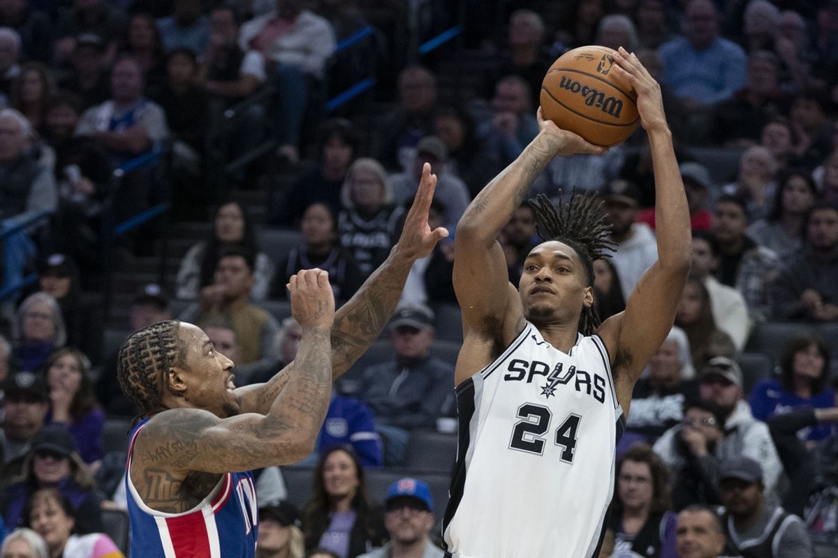 December 1, 2024; Sacramento, California, USA; San Antonio Spurs guard Devin Vassell (24) shoots the basketball against Sacramento Kings forward DeMar DeRozan (10) during the fourth quarter at Golden 1 Center. Mandatory Credit: Kyle Terada-Imagn Images