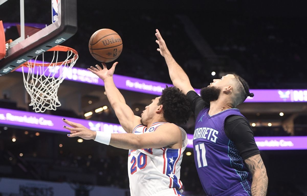Dec 3, 2024; Charlotte, North Carolina, USA;  Philadelphia 76ers guard Jared McCain (20) drives in past Charlotte Hornets guard Cody Martin (11) during the first half at the Spectrum Center. Mandatory Credit: Sam Sharpe-Imagn Images