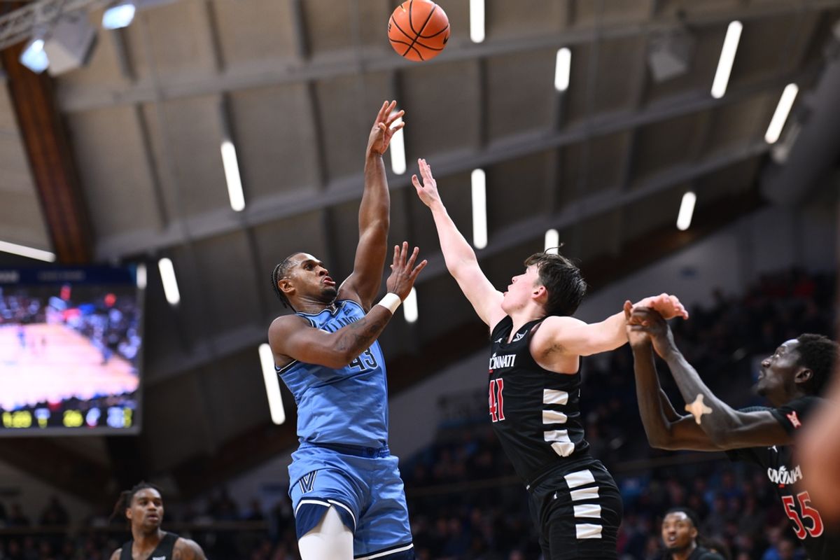 Dec 3, 2024; Villanova, Pennsylvania, USA; Villanova Wildcats forward Eric Dixon (43) shoots over Cincinnati Bearcats guard Simas Lukosius (41) in the first half at William B. Finneran Pavilion. Mandatory Credit: Kyle Ross-Imagn Images