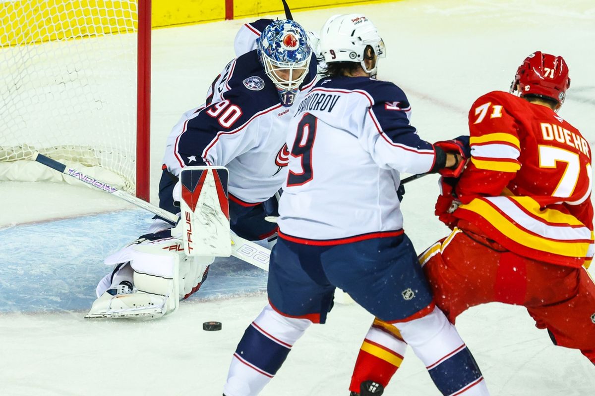 Dec 3, 2024; Calgary, Alberta, CAN; Columbus Blue Jackets goaltender Elvis Merzlikins (90) makes a save against Calgary Flames right wing Walker Duehr (71) during the first period at Scotiabank Saddledome. Mandatory Credit: Sergei Belski-Imagn Images