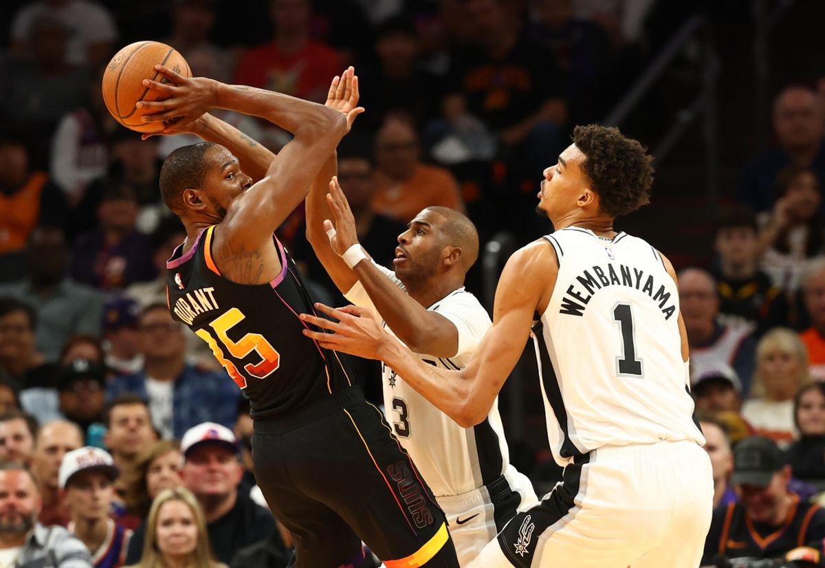 Dec 3, 2024; Phoenix, Arizona, USA; Phoenix Suns forward Kevin Durant (35) against San Antonio Spurs guard Chris Paul (3) and center Victor Wembanyama (1) in the first half of an NBA Cup game at Footprint Center. Mandatory Credit: Mark J. Rebilas-Imagn Images