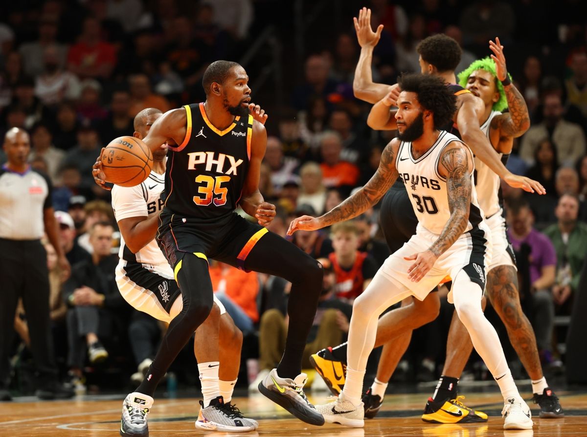 Dec 3, 2024; Phoenix, Arizona, USA; Phoenix Suns forward Kevin Durant (35) against San Antonio Spurs forward Julian Champagnie (30) in the first half of an NBA Cup game at Footprint Center. Mandatory Credit: Mark J. Rebilas-Imagn Images