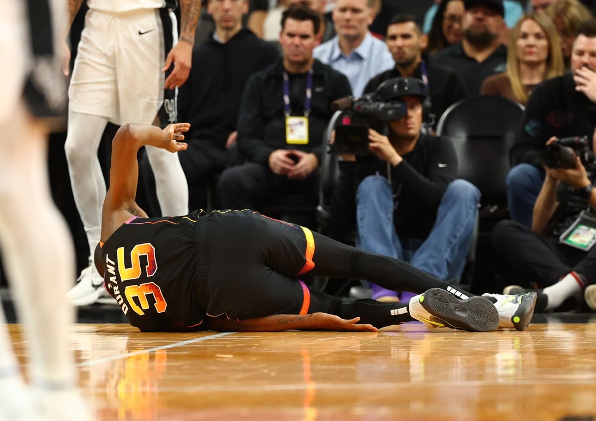 Dec 3, 2024; Phoenix, Arizona, USA; Phoenix Suns forward Kevin Durant (35) falls to the ground after rolling his ankle against the San Antonio Spurs in the first half of an NBA Cup game at Footprint Center. Mandatory Credit: Mark J. Rebilas-Imagn Images