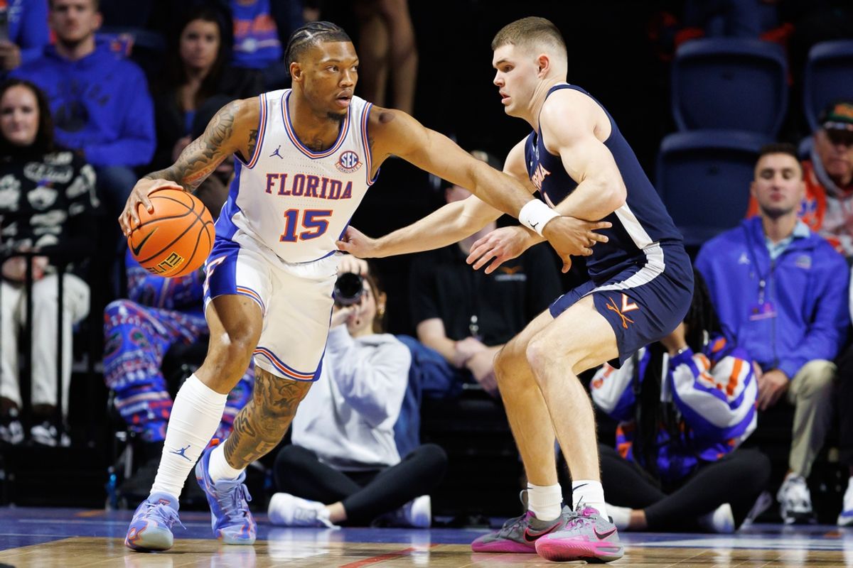Dec 4, 2024; Gainesville, Florida, USA; Florida Gators guard Alijah Martin (15) dribbles past Virginia Cavaliers guard Isaac McKneely (11) during the first half at Exactech Arena at the Stephen C. O'Connell Center. Mandatory Credit: Matt Pendleton-Imagn Images