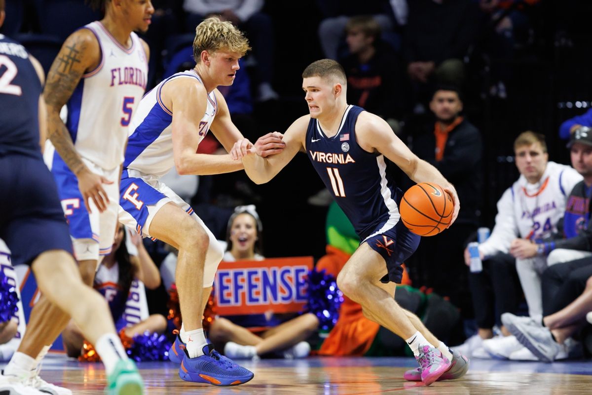 Dec 4, 2024; Gainesville, Florida, USA; Virginia Cavaliers guard Isaac McKneely (11) dribbles the ball at Florida Gators forward Thomas Haugh (10) during the second half at Exactech Arena at the Stephen C. O'Connell Center. Mandatory Credit: Matt Pendleton-Imagn Images