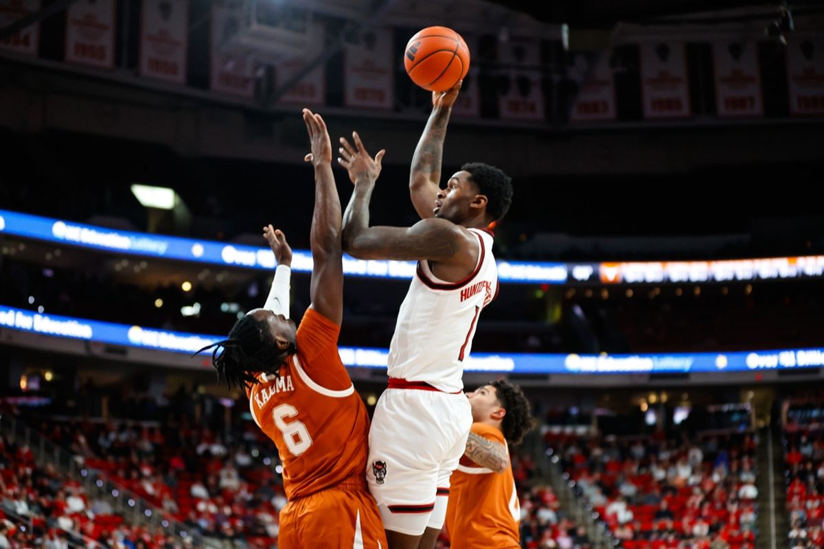 Dec 4, 2024; Raleigh, North Carolina, USA;  North Carolina State Wolfpack forward Brandon Huntley-Hatfield (1) shoots the ball past Texas Longhorns forward Arthur Kaluma (6) during the first half of the game at Lenovo Center. Mandatory Credit: Jaylynn Nash-Imagn Images
