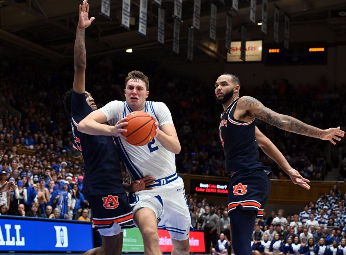 Dec 4, 2024; Durham, North Carolina, USA; Duke Blue Devils forward Cooper Flagg (2) drives to the basket between Auburn Tigers guard Tahaad Pettiford (0) and center Johni Broome (4) during the second half at Cameron Indoor Stadium. The Blue Devils won 84-78.   Mandatory Credit: Rob Kinnan-Imagn Images