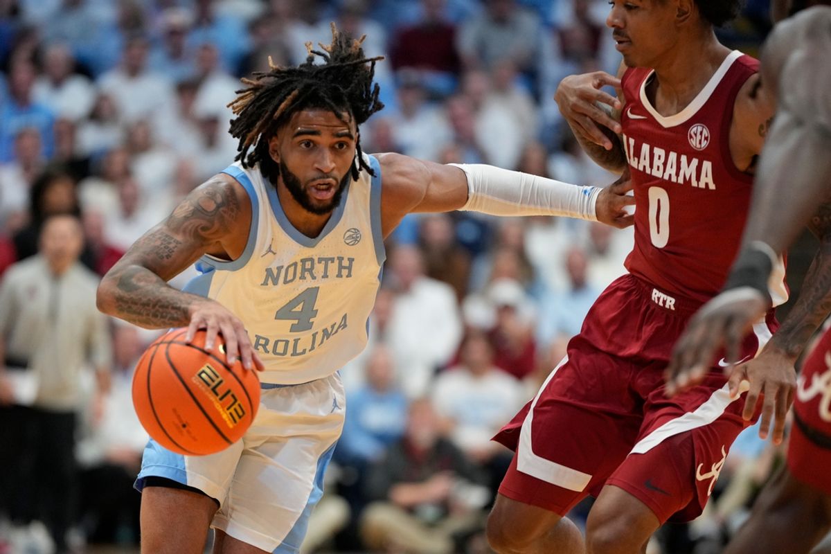 Dec 4, 2024; Chapel Hill, North Carolina, USA; North Carolina Tar Heels guard RJ Davis (4) with the ball as Alabama Crimson Tide guard Labaron Philon (0) defends in the second half at Dean E. Smith Center. Mandatory Credit: Bob Donnan-Imagn Images