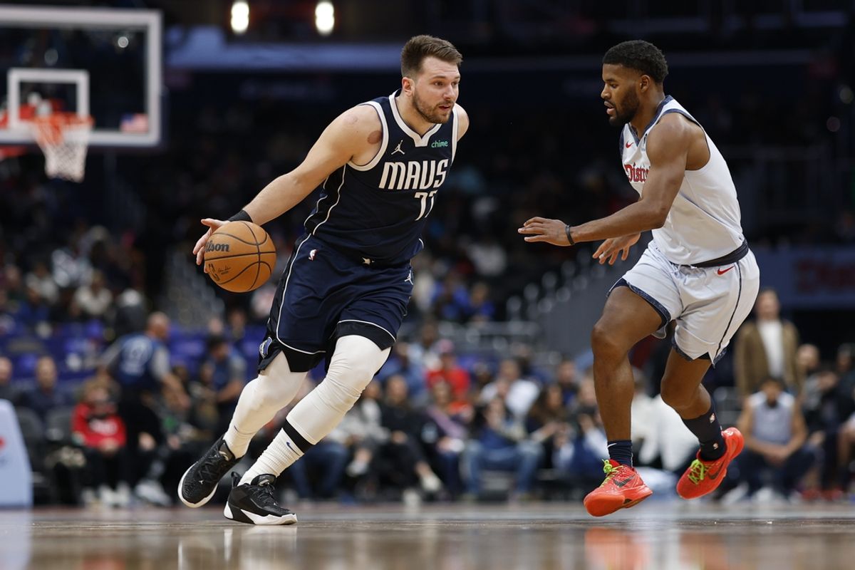 Dec 5, 2024; Washington, District of Columbia, USA; Dallas Mavericks guard Luka Doncic (77) drives to the basket as Washington Wizards guard Jared Butler (4) defends in the second quarter at Capital One Arena. Mandatory Credit: Geoff Burke-Imagn Images