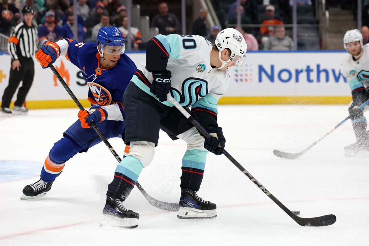 Dec 5, 2024; Elmont, New York, USA; Seattle Kraken right wing Eeli Tolvanen (20) controls the puck against New York Islanders defenseman Isaiah George (36) during the first period at UBS Arena. Mandatory Credit: Brad Penner-Imagn Images