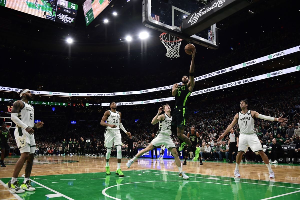 Dec 6, 2024; Boston, Massachusetts, USA;  Boston Celtics forward Jayson Tatum (0) lays the ball in the basket past Milwaukee Bucks guard AJ Green (20) during the second half at TD Garden. Mandatory Credit: Bob DeChiara-Imagn Images