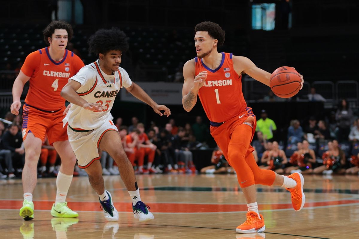 Dec 7, 2024; Coral Gables, Florida, USA; Clemson Tigers guard Chase Hunter (1) drives to the basket against Miami Hurricanes guard Austin Swartz (23) during the first half at Watsco Center. Mandatory Credit: Sam Navarro-Imagn Images