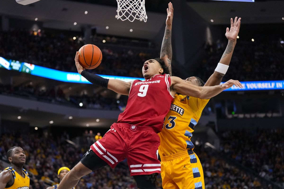 Dec 7, 2024; Milwaukee, Wisconsin, USA;  Wisconsin Badgers guard John Tonje (9) shoots in front of Marquette Golden Eagles forward David Joplin (23) during the first half at Fiserv Forum. Mandatory Credit: Jeff Hanisch-Imagn Images