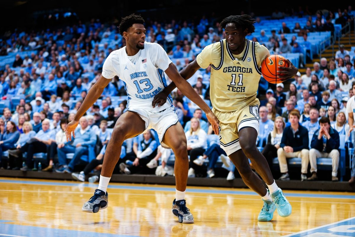 Dec 7, 2024; Chapel Hill, North Carolina, USA; Georgia Tech Yellow Jackets forward Baye Ndongo (11) dribbles with the ball guarded by North Carolina Tar Heels forward Jalen Washington (13) during the first half of the game at Dean E. Smith Center. Mandatory Credit: Jaylynn Nash-Imagn Images
