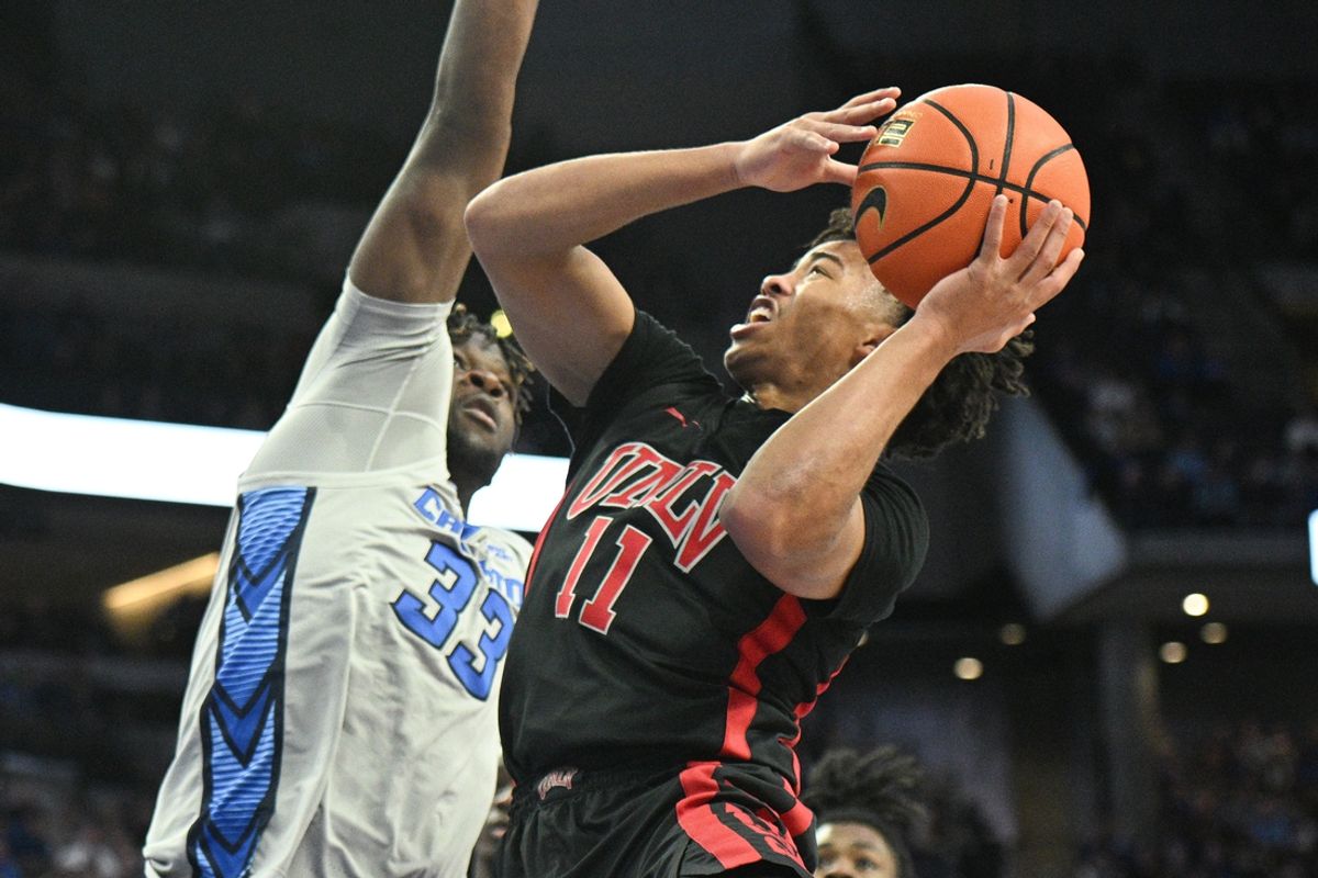 Dec 7, 2024; Omaha, Nebraska, USA;  UNLV Rebels guard Dedan Thomas Jr. (11) drives against Creighton Bluejays center Fredrick King (33) in the first half at CHI Health Center Omaha. Mandatory Credit: Steven Branscombe-Imagn Images