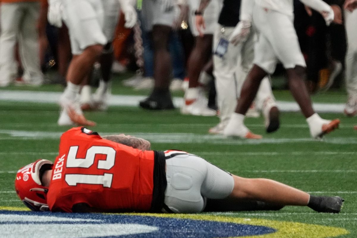Georgia quarterback Carson Beck (15) goes down after a hit on this trowing shoulder during the first half of the SEC championship game against Texas in Atlanta, on Saturday, Dec. 7, 2024.