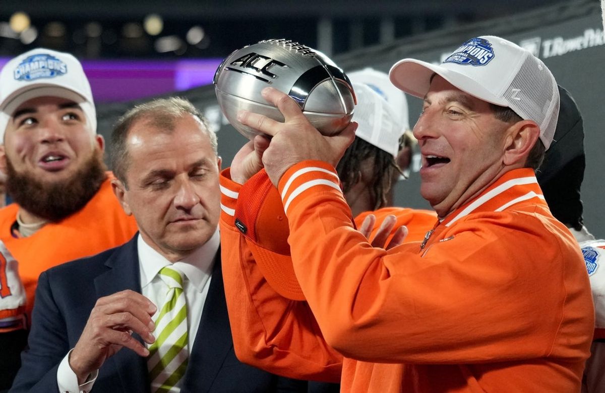 Dec 7, 2024; Charlotte, NC, USA; ACC commissioner James Phillips presents Clemson Tigers head coach Dabo Swinney with the trophy after the Tigers won the 2024 ACC Championship game against the Southern Methodist Mustangs at Bank of America Stadium. Mandatory Credit: Jim Dedmon-Imagn Images