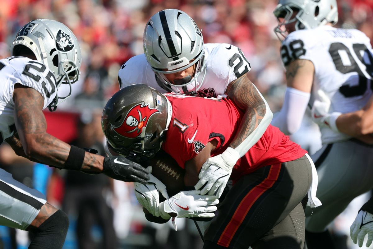 Dec 8, 2024; Tampa, Florida, USA; Las Vegas Raiders safety Isaiah Pola-Mao (20) tackles Tampa Bay Buccaneers running back Rachaad White (1) during the first half at Raymond James Stadium. Mandatory Credit: Kim Klement Neitzel-Imagn Images