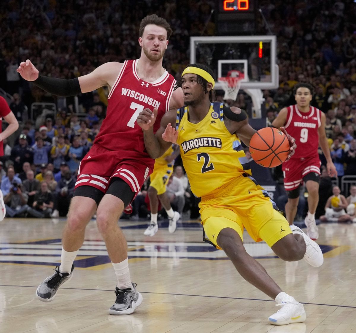 Marquette guard Chase Ross (2) drives past Wisconsin forward Carter Gilmore (7) during the first half of their game Saturday, Dec. 7, 2024, at Fiserv Forum in Milwaukee, Wisconsin.