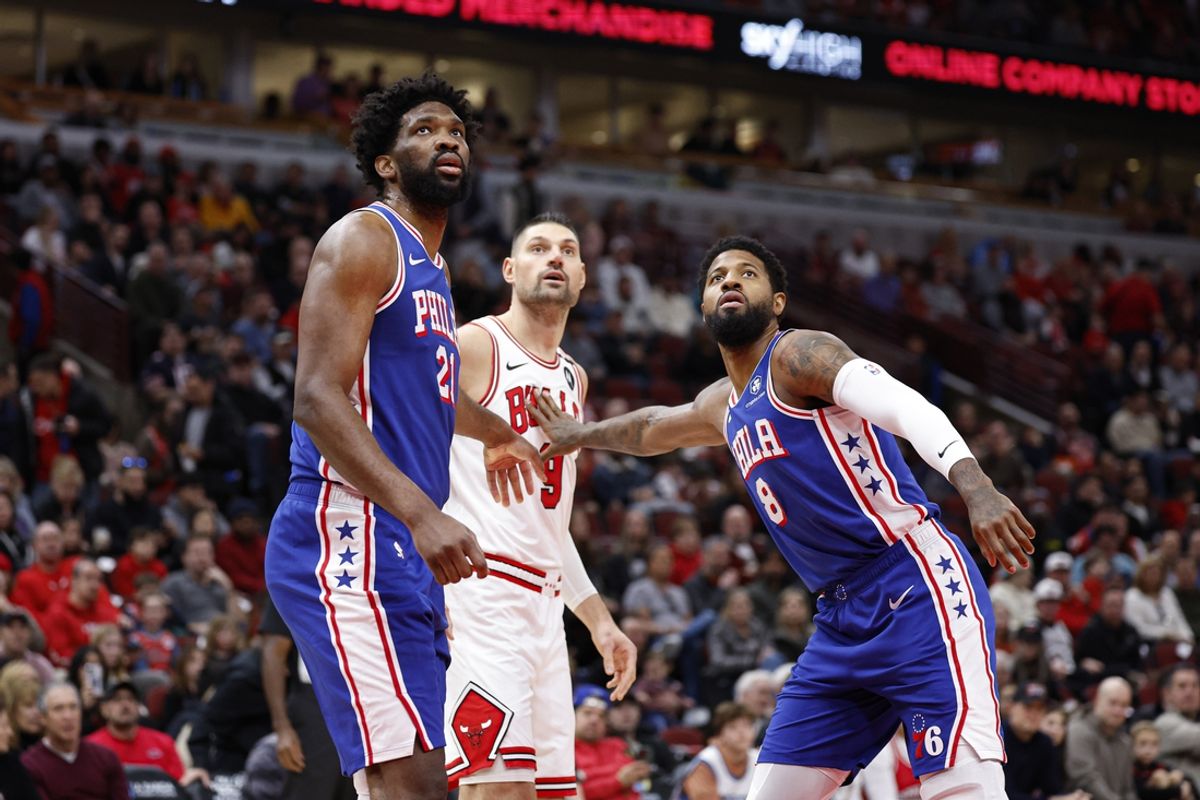 Dec 8, 2024; Chicago, Illinois, USA; Philadelphia 76ers center Joel Embiid (21) and forward Paul George (8) defend against Chicago Bulls center Nikola Vucevic (9) during the first half at United Center. Mandatory Credit: Kamil Krzaczynski-Imagn Images