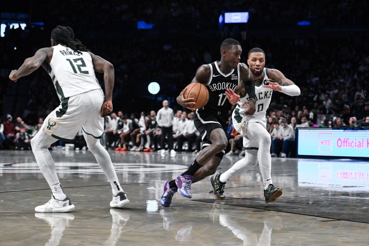 Dec 8, 2024; Brooklyn, New York, USA; Brooklyn Nets guard Dennis Schroder (17) drives to the basket while being defended by Milwaukee Bucks guard Damian Lillard (0) during the first half at Barclays Center. Mandatory Credit: John Jones-Imagn Images