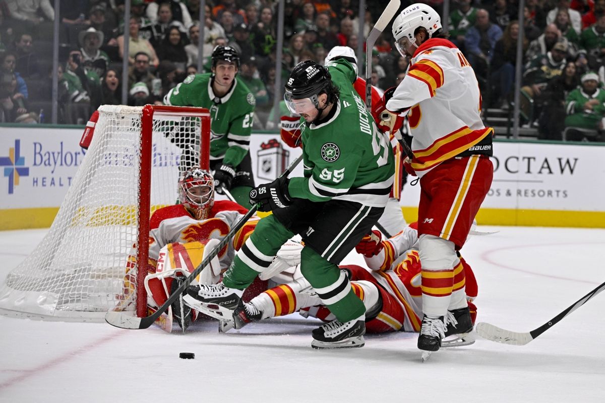 Dec 8, 2024; Dallas, Texas, USA; Dallas Stars center Matt Duchene (95) attempts to poke the puck past Calgary Flames goaltender Dustin Wolf (32) and defenseman Rasmus Andersson (4) during the second period at the American Airlines Center. Mandatory Credit: Jerome Miron-Imagn Images