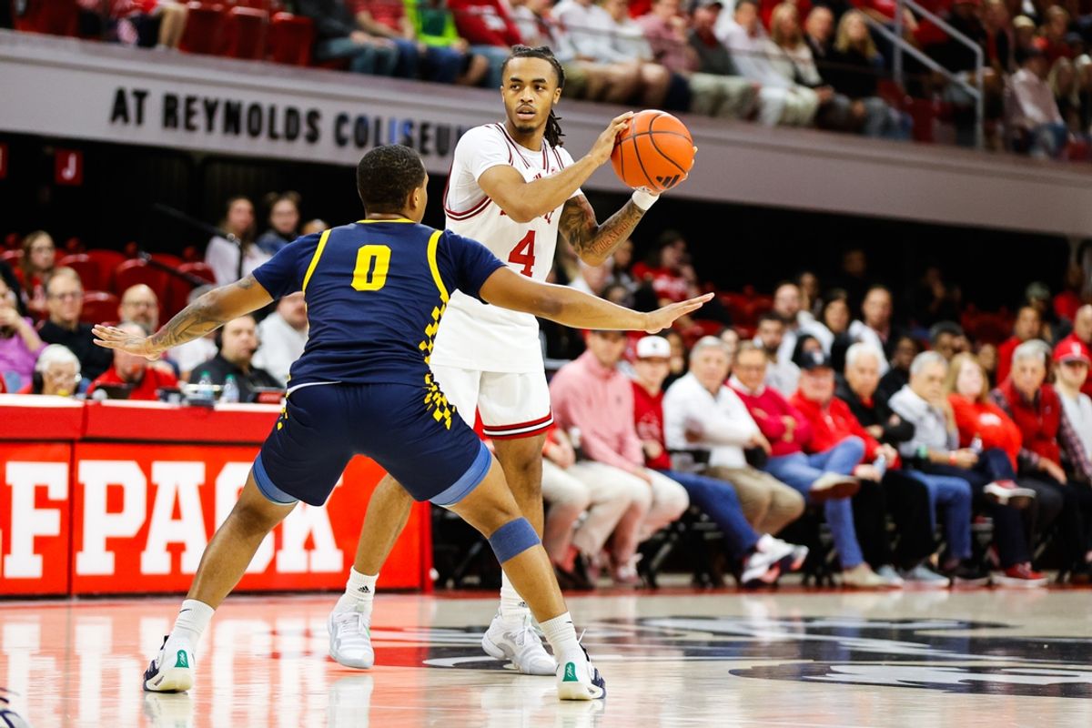 Dec 10, 2024; Raleigh, North Carolina, USA; North Carolina State Wolfpack guard Breon Pass (4) dribbles the ball agaisnt Coppin State Eagles guard Zahree Harrison (0) during the first half of the game at Reynolds Coliseum. Mandatory Credit: Jaylynn Nash-Imagn Images