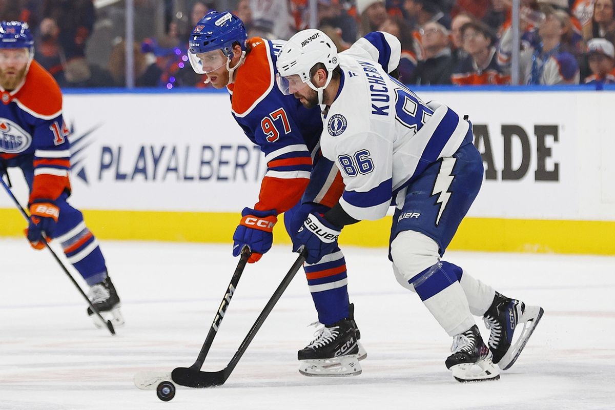 Dec 10, 2024; Edmonton, Alberta, CAN; Tampa Bay Lightning forward Nikita Kucherov (86) and Edmonton Oilers forward Connor McDavid (97) battle for a loose puck during the first period at Rogers Place. Mandatory Credit: Perry Nelson-Imagn Images