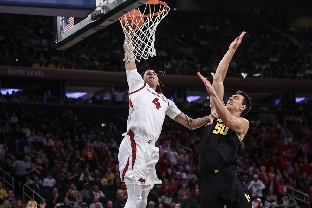 Dec 10, 2024; New York, New York, USA;  Arkansas Razorbacks forward Trevon Brazile (4) dunks past Michigan Wolverines center Vladislav Goldin (50) in the first half at Madison Square Garden. Mandatory Credit: Wendell Cruz-Imagn Images