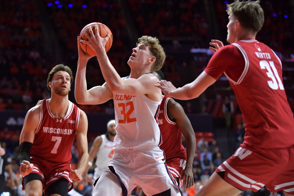 Dec 10, 2024; Champaign, Illinois, USA;  Illinois Fighting Illini guard Kasparas Jakucionis (32) drives between Wisconsin Badgers forward Carter Gilmore (7) and Nolan Winter (31) during the first half at State Farm Center. Mandatory Credit: Ron Johnson-Imagn Images