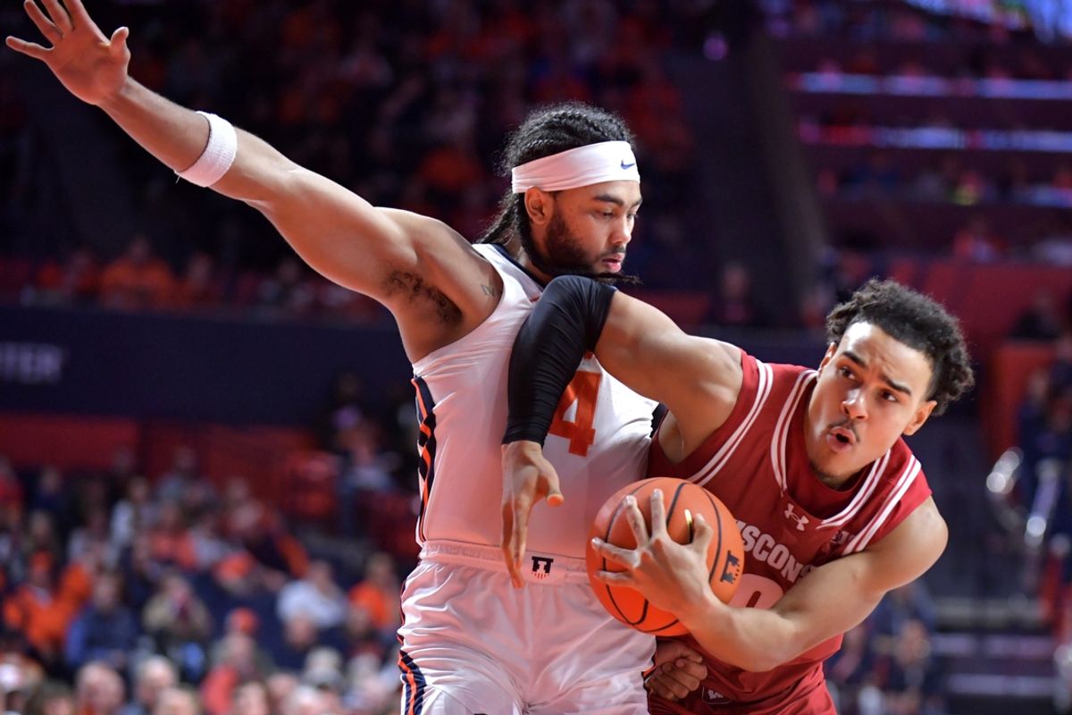 Dec 10, 2024; Champaign, Illinois, USA;  Wisconsin Badgers guard John Tonje (9) drives the ball around Illinois Fighting Illini guard Kylan Boswell (4) during the second half at State Farm Center. Mandatory Credit: Ron Johnson-Imagn Images
