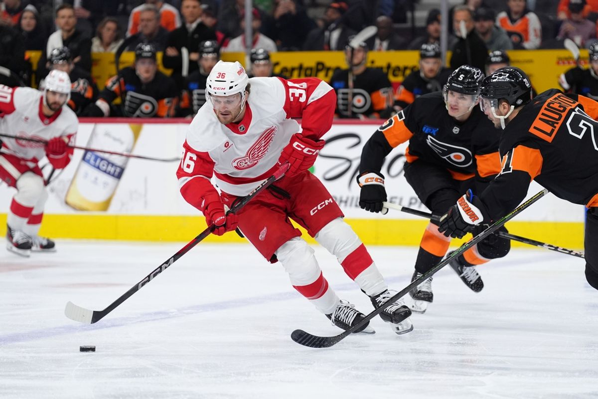 Dec 12, 2024; Philadelphia, Pennsylvania, USA; Detroit Red Wings right wing Christian Fischer (36) pushes the puck past Philadelphia Flyers center Scott Laughton (21) in the first period at Wells Fargo Center. Mandatory Credit: Kyle Ross-Imagn Images