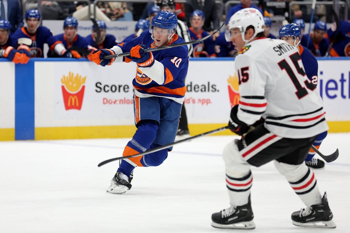 Dec 12, 2024; Elmont, New York, USA; New York Islanders right wing Simon Holmstrom (10) follows through on a goal scoring shot against Chicago Blackhawks center Craig Smith (15) during the second period at UBS Arena. Mandatory Credit: Brad Penner-Imagn Images