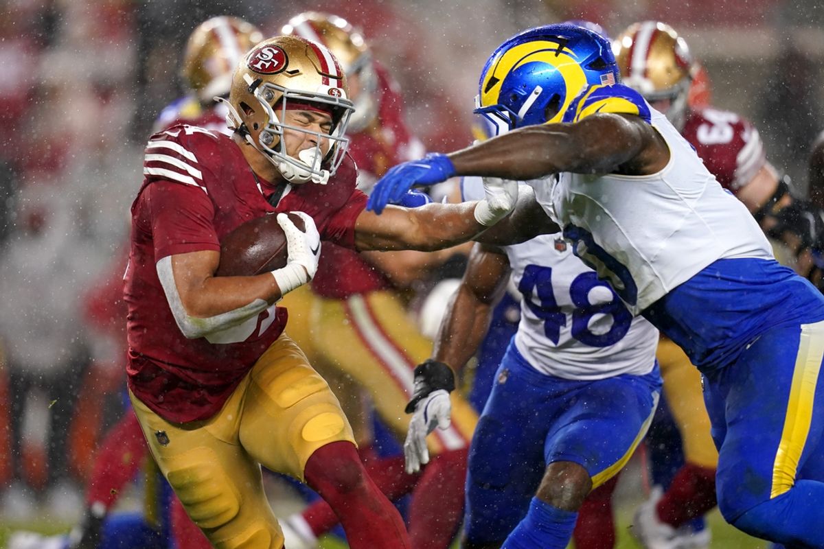Dec 12, 2024; Santa Clara, California, USA; San Francisco 49ers running back Isaac Guerendo (31) runs the ball as Los Angeles Rams linebacker Byron Young (0) defends in the second quarter at Levi's Stadium. Mandatory Credit: Cary Edmondson-Imagn Images