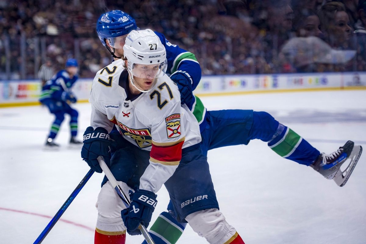 Dec 12, 2024; Vancouver, British Columbia, CAN; Vancouver Canucks forward Elias Pettersson (40) checks Florida Panthers forward Eetu Luostarinen (27) during the second period at Rogers Arena. Mandatory Credit: Bob Frid-Imagn Images