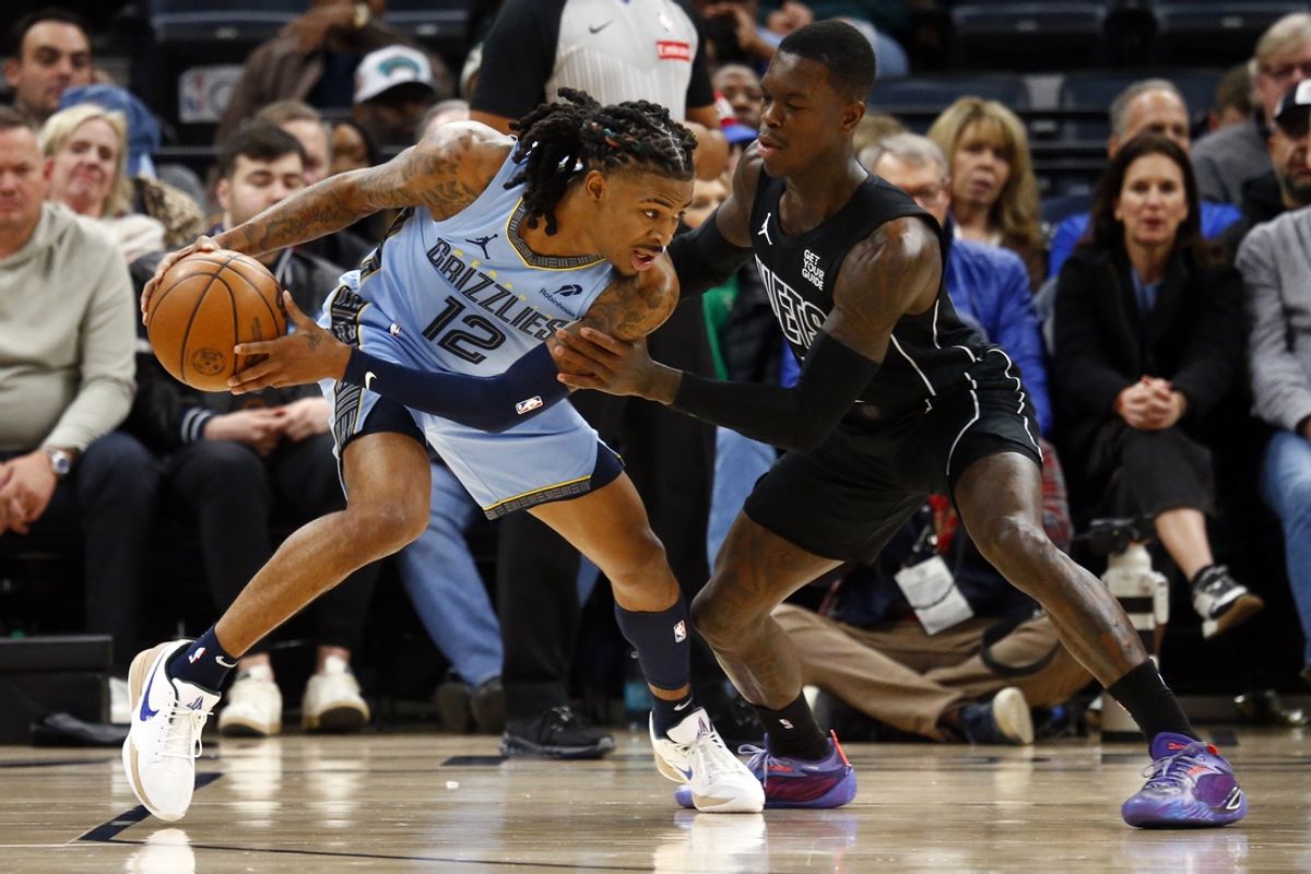 Dec 13, 2024; Memphis, Tennessee, USA; Memphis Grizzlies guard Ja Morant (12) handles the ball as Brooklyn Nets guard Dennis Schroder (17) defends during the first quarter at FedExForum. Mandatory Credit: Petre Thomas-Imagn Images