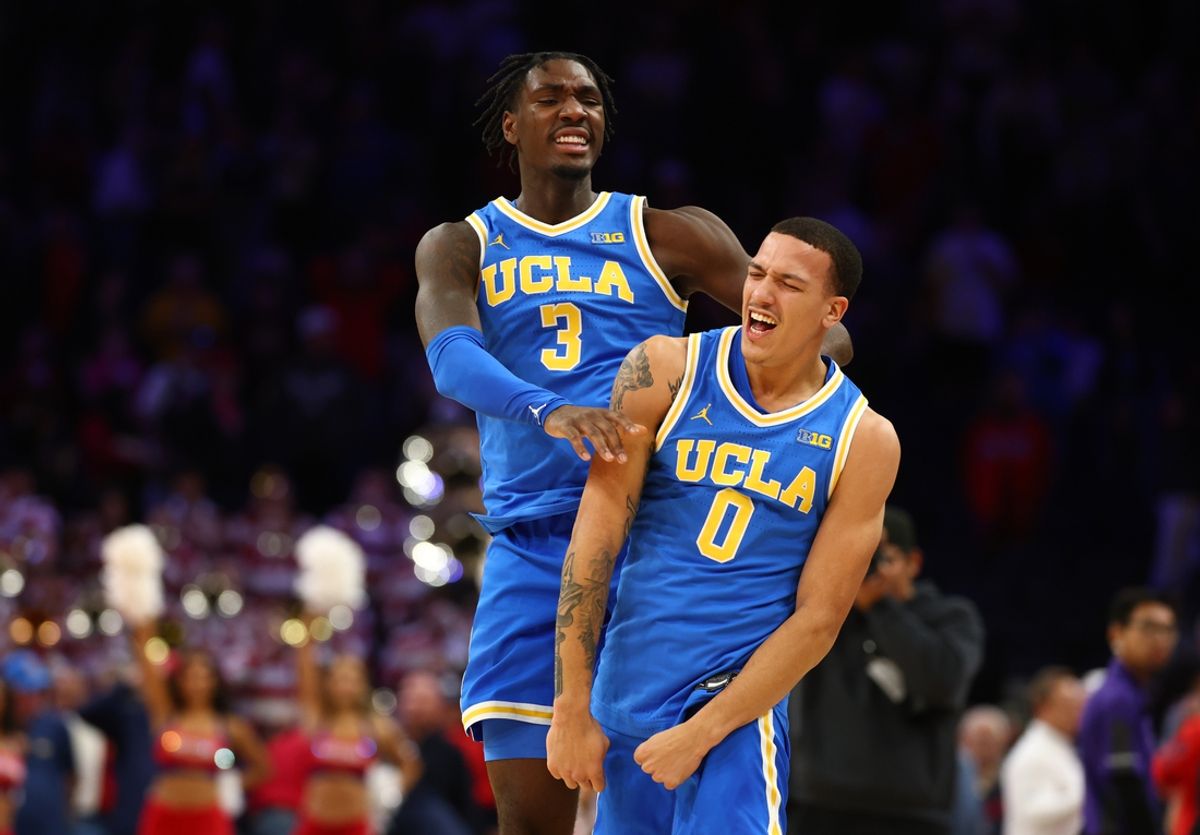 Dec 14, 2024; Phoenix, Arizona, USA; UCLA Bruins guard Kobe Johnson (0) celebrates with Eric Dailey Jr. (3) after defeating the Arizona Wildcats at Footprint Center. Mandatory Credit: Mark J. Rebilas-Imagn Images