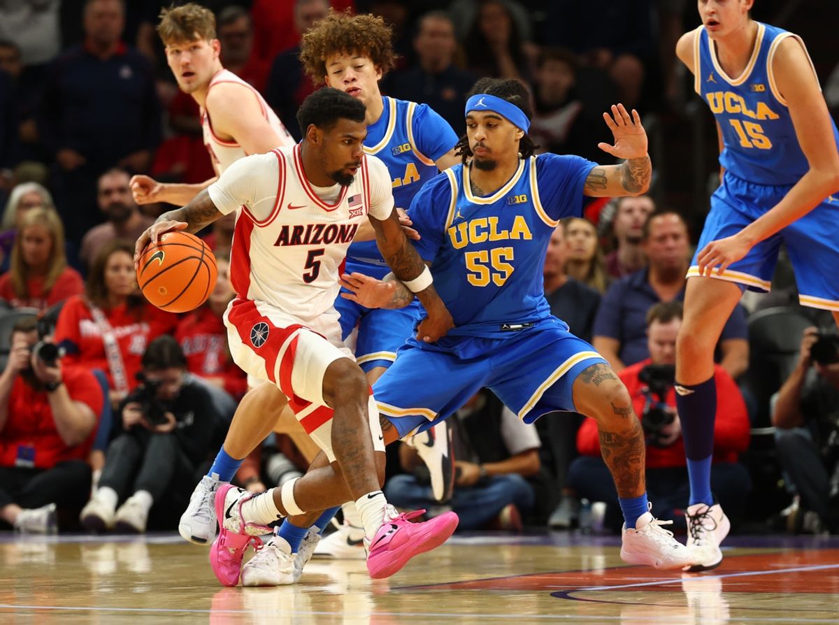 Dec 14, 2024; Phoenix, Arizona, USA; Arizona Wildcats guard KJ Lewis (5) controls the ball against UCLA Bruins guard Skyy Clark (55) in the second half at Footprint Center. Mandatory Credit: Mark J. Rebilas-Imagn Images