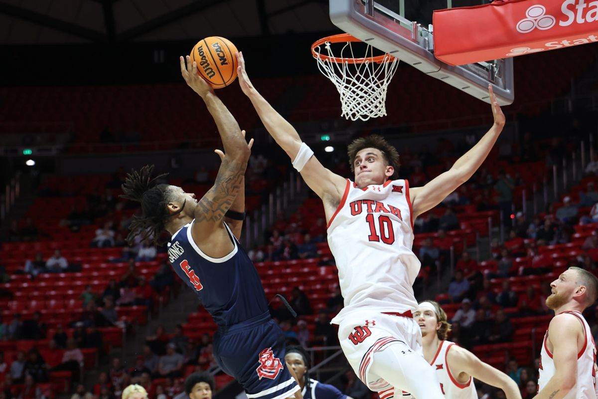 Dec 14, 2024; Salt Lake City, Utah, USA; Radford Highlanders forward Isaiah Gaines (6) goes to the basket against Utah Utes forward Jake Wahlin (10) during the first half at Jon M. Huntsman Center. Mandatory Credit: Rob Gray-Imagn Images