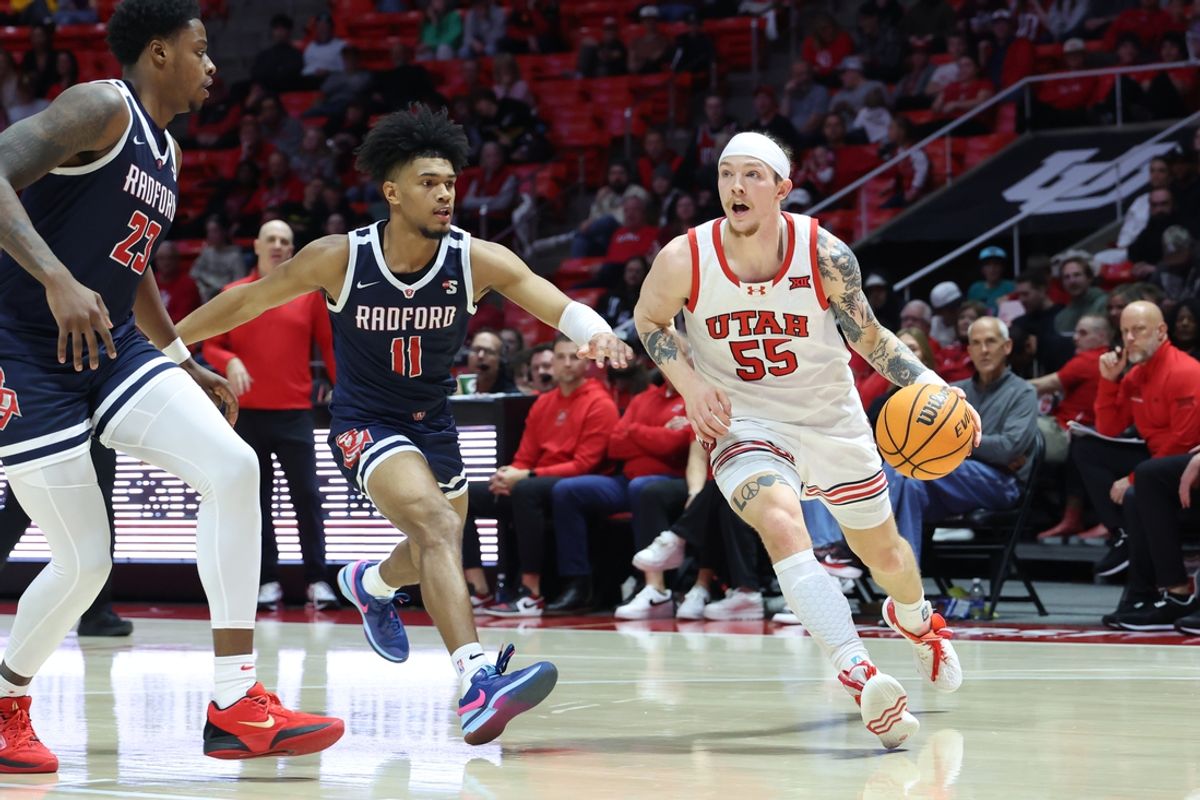 Dec 14, 2024; Salt Lake City, Utah, USA; Utah Utes guard Gabe Madsen (55) drives to the basket against Radford Highlanders guard Jarvis Moss (11) during the second half at Jon M. Huntsman Center. Mandatory Credit: Rob Gray-Imagn Images