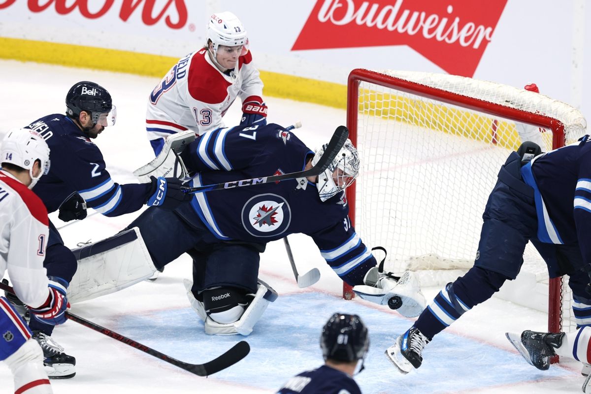 Dec 14, 2024; Winnipeg, Manitoba, CAN; Winnipeg Jets goaltender Connor Hellebuyck (37) stretches to make a glove save in the third period against the Montreal Canadiens at Canada Life Centre. Mandatory Credit: James Carey Lauder-Imagn Imagess