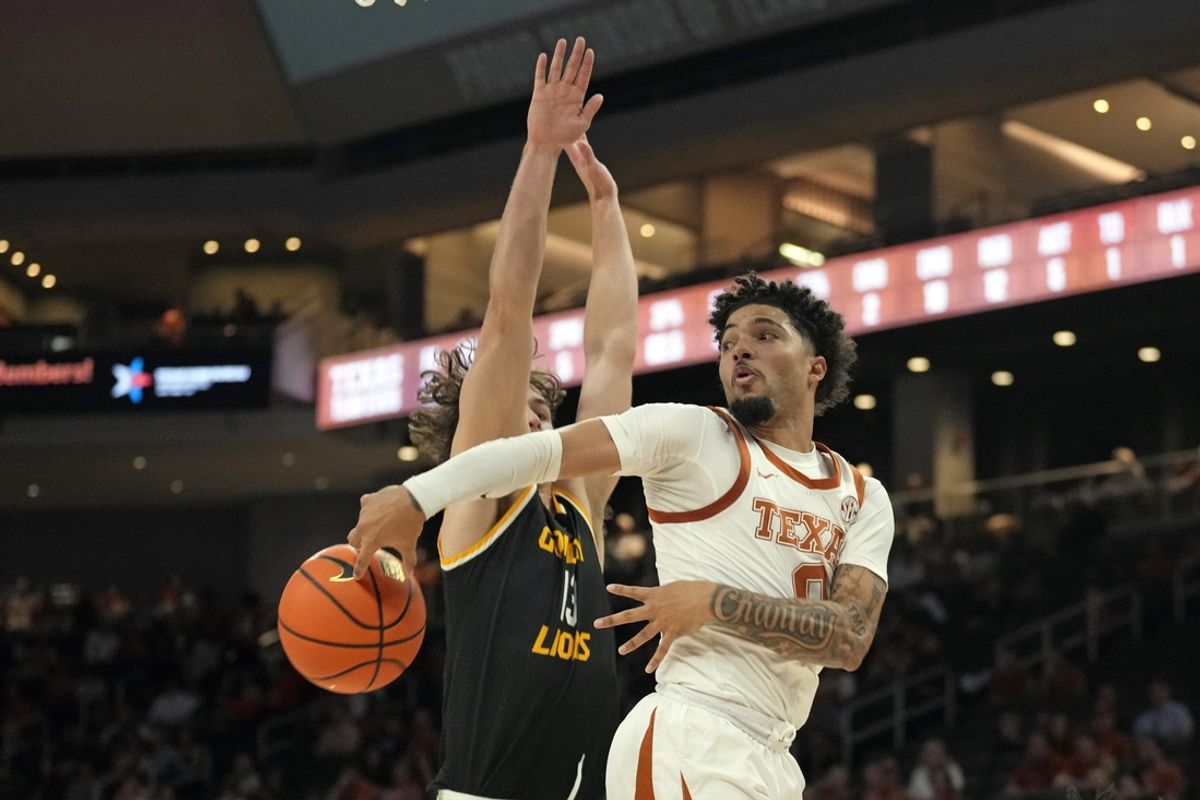 Dec 15, 2024; Austin, Texas, USA; Texas Longhorns guard Jordan Pope (0) passes the ball around Arkansas-Pine Bluff Golden Lions guard Raphael Dumont (13) during the first half at Moody Center. Mandatory Credit: Scott Wachter-Imagn Images