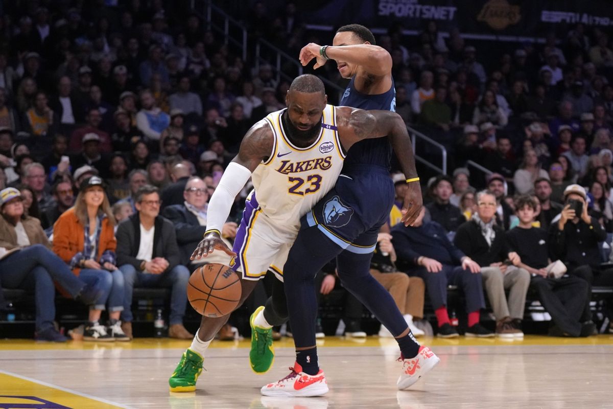 Dec 15, 2024; Los Angeles, California, USA; Los Angeles Lakers forward LeBron James (23) dribbles the ball against Memphis Grizzlies guard Desmond Bane (22) in the first half at Crypto.com Arena. Mandatory Credit: Kirby Lee-Imagn Images