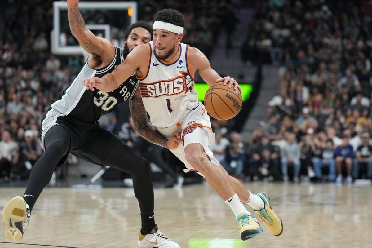 Mar 23, 2024; San Antonio, Texas, USA;  Phoenix Suns guard Devin Booker (1) dribbles against San Antonio Spurs forward Julian Champagnie (30) in the second half at Frost Bank Center.