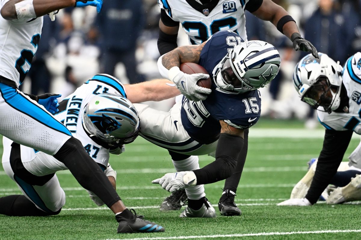 Dec 15, 2024; Charlotte, North Carolina, USA;  Dallas Cowboys running back Ezekiel Elliott (15) is tackled by Carolina Panthers linebacker Josey Jewell (47) in the third quarter at Bank of America Stadium. Mandatory Credit: Bob Donnan-Imagn Images