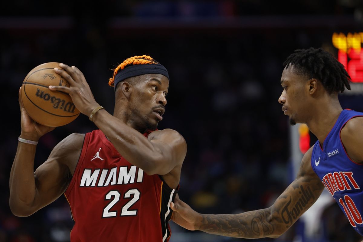 Dec 16, 2024; Detroit, Michigan, USA;  Miami Heat forward Jimmy Butler (22) controls the ball as Detroit Pistons forward Ronald Holland II (00) defends in the first half at Little Caesars Arena. Mandatory Credit: Rick Osentoski-Imagn Images